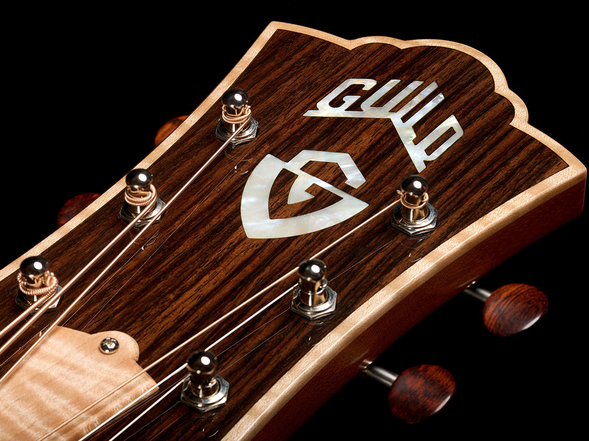 Close-up of VR1 F-40 Au Naturel guitar’s headstock showcasing the Indian rosewood headstock overlay with mother-of-pearl Guild Peak logo and Waverly tuners with snakewood buttons