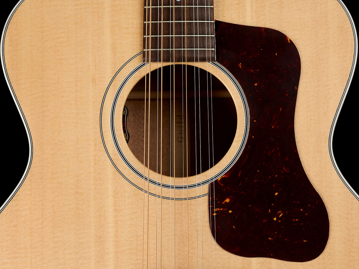 Close-up of The F-412E Standard Natural body showing the soundhole and pickguard