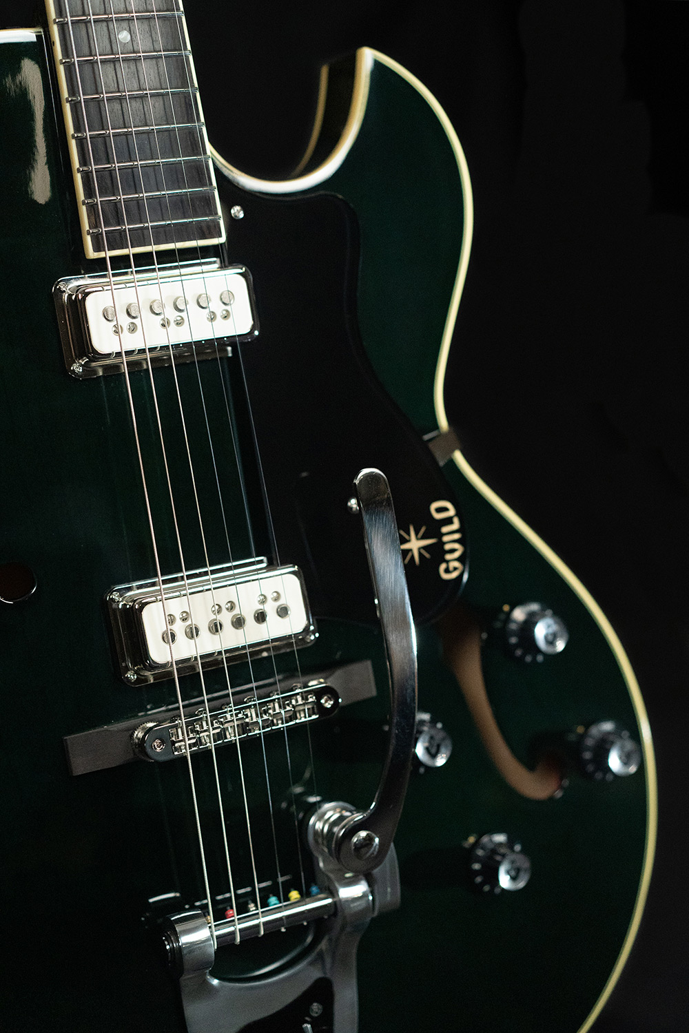Close up view of Starfire III Dynasonic Emerald Green body and pickguard