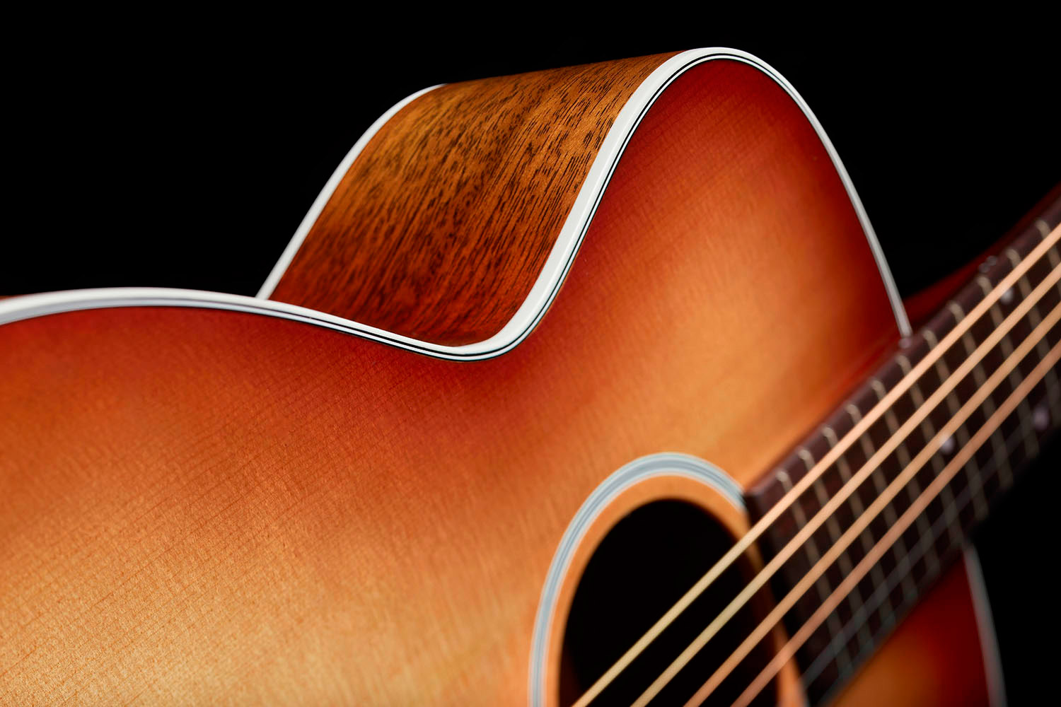 Close-up of M-40 Standard Pacific Sunset Burst showcasing solid Sitka Spruce top and White ABS body binding