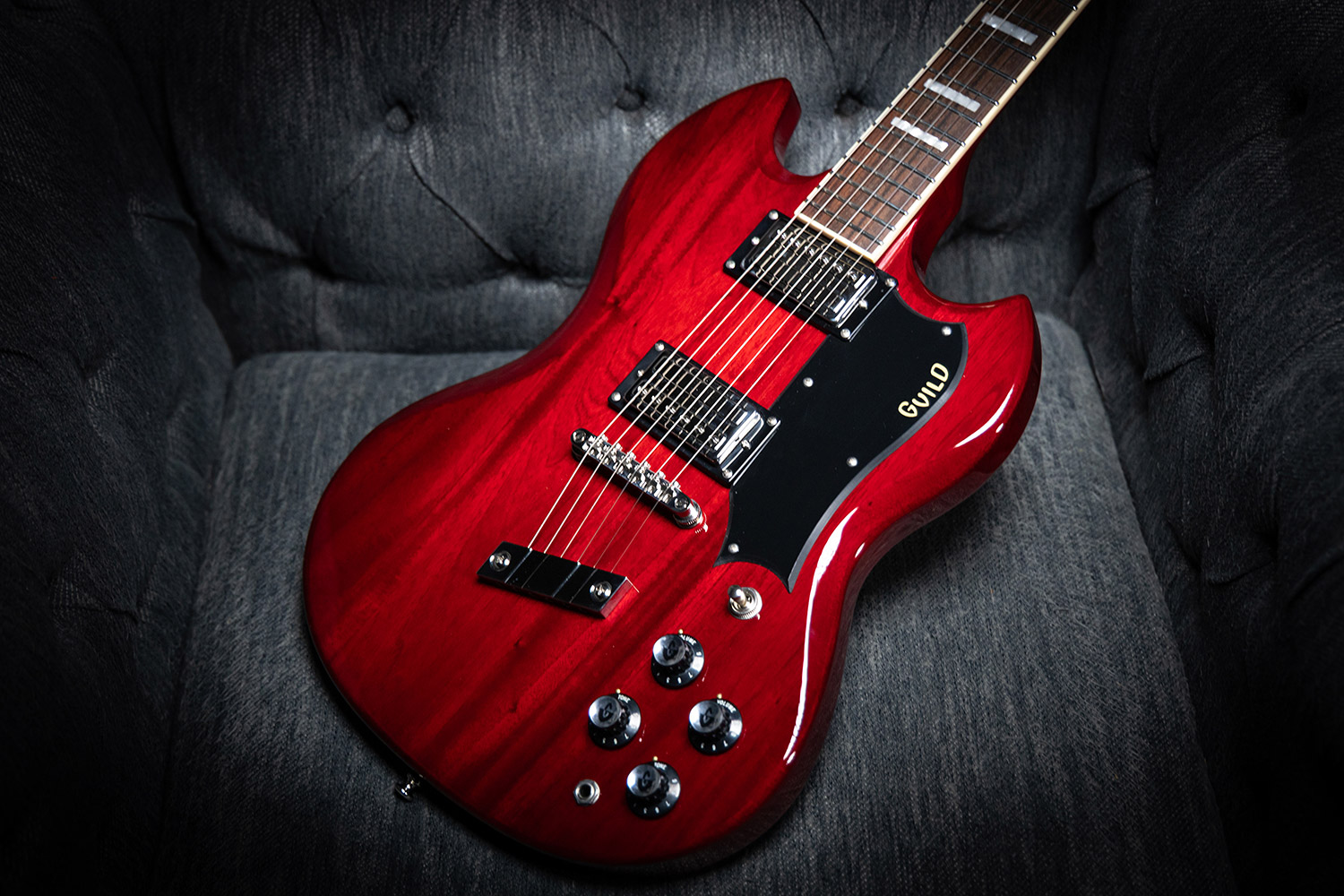 Polara Deluxe Cherry Red laying on a gray couch