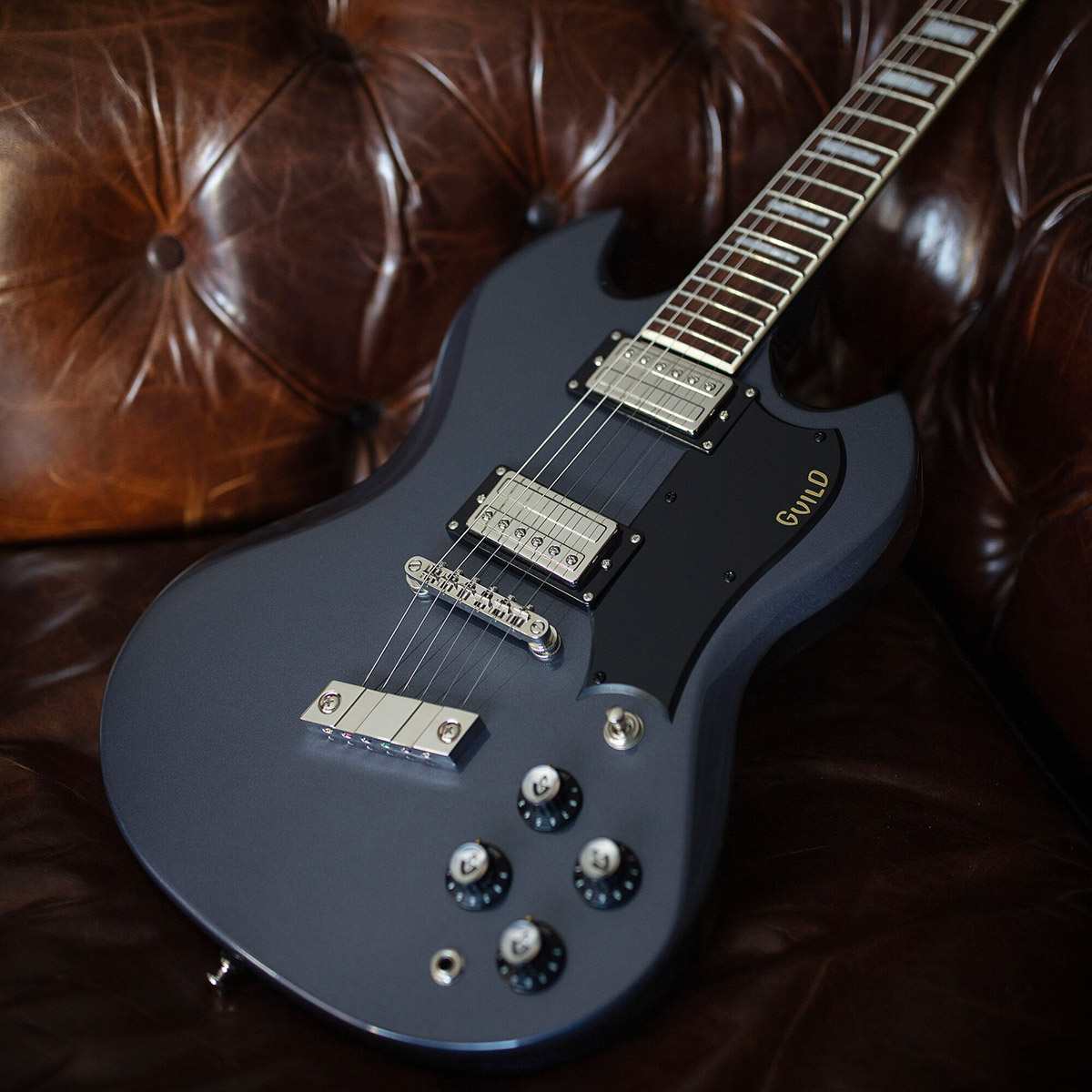 Polara Deluxe Canyon Dusk leaning on arm of a leather couch