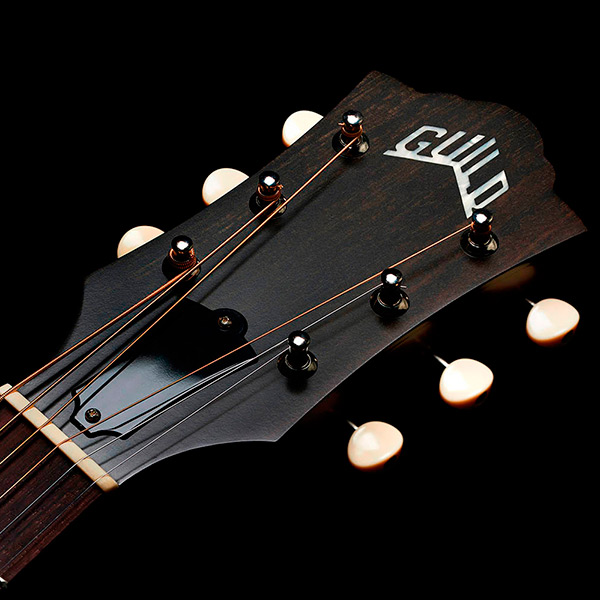 Close-up of front of the M-40 Standard Natural headstock with Guild Peak logo thumb