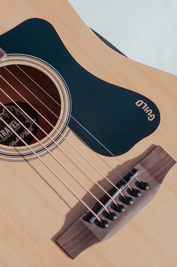 Close up of Travel Spruce pickguard and bridge thumbnail