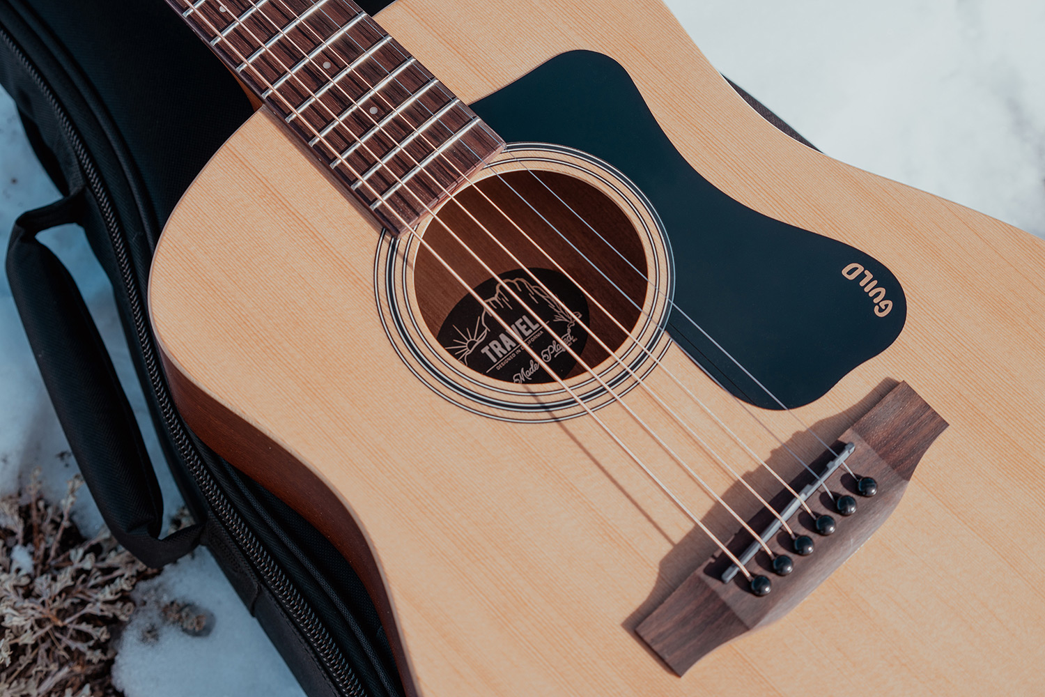 Close up of Travel Spruce pickguard and bridge