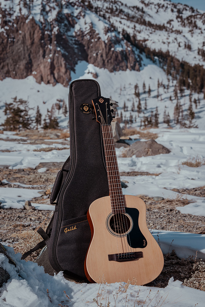 Travel Spruce acoustic guitar with gig bag  in a rocky snowy landscape