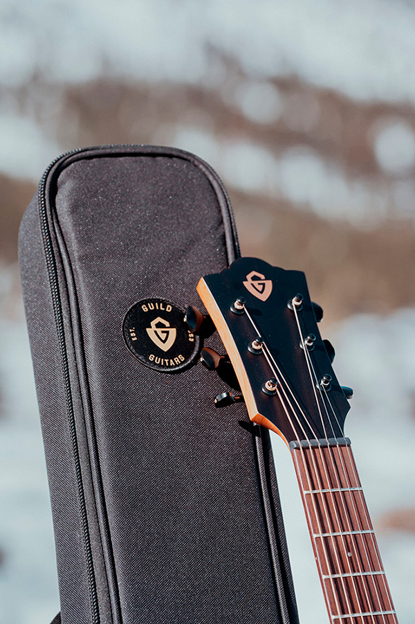 Close up of Travel Spruce head stock and top of gig bag with snowy landscape behind thumbnail