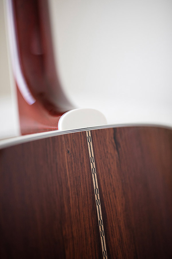 Close-up of GSR D-55 70th Anniversary Limited guitar's neck joint, showcasing polished wood grain and decorative inlay along the seam.