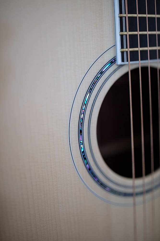 Close-up of GSR D-55 70th Anniversary Limited acoustic guitar's soundhole and strings, showcasing intricate inlay details around the soundhole.