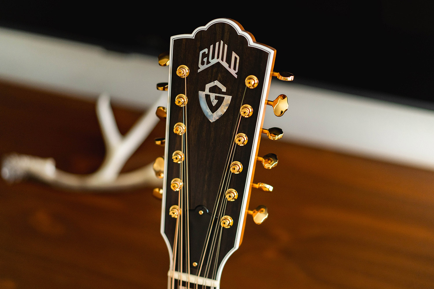 Close up of Guild F-512 Maple headstock with Guild Peak logo