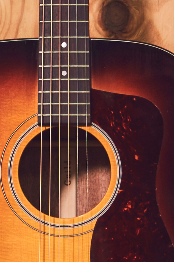Close-up of D-40 acoustic guitar's neck and body, showcasing the strings, fretboard, and soundhole.