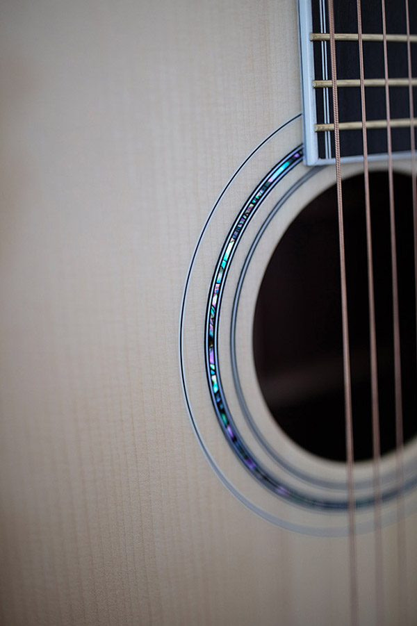 Close-up of GSR D-55 70th Anniversary Limited acoustic guitar's soundhole and strings, showcasing intricate inlay details around the soundhole.