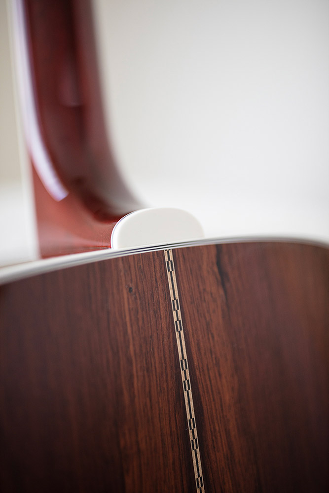 Close-up of GSR D-55 70th Anniversary Limited guitar neck featuring intricate inlays and gold tuning pegs. The strings are visible against a dark wood fretboard.