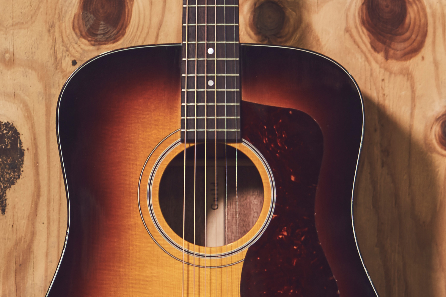 Close-up of D-40 acoustic guitar's neck and body, showcasing the strings, fretboard, and soundhole.